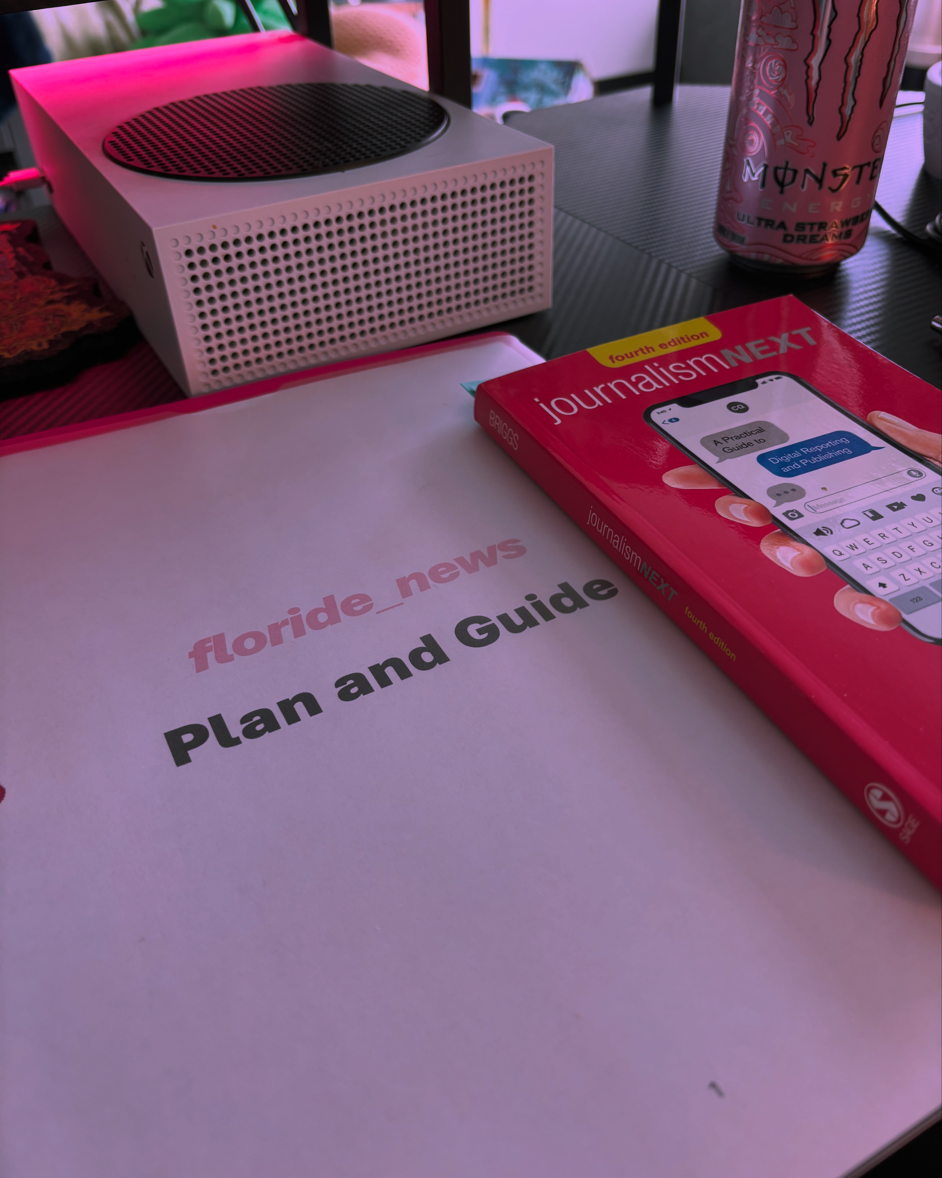 A folder reads - floride_news: Plan and Guide and a pink book called - Journalism Next, by Mark Briggs